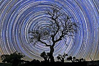 Színes csillagpályák örvénylik a Polaris körül a hipnotikus éjszakai égbolt fotójában