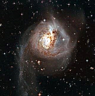 ゴージャスなハッブル写真での長い前の衝突の輝きによって歪められた銀河