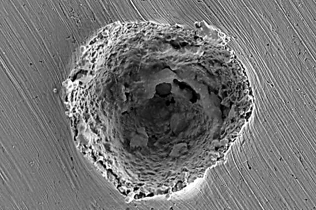 Mikrometeoritenschaden unter dem Mikroskop
